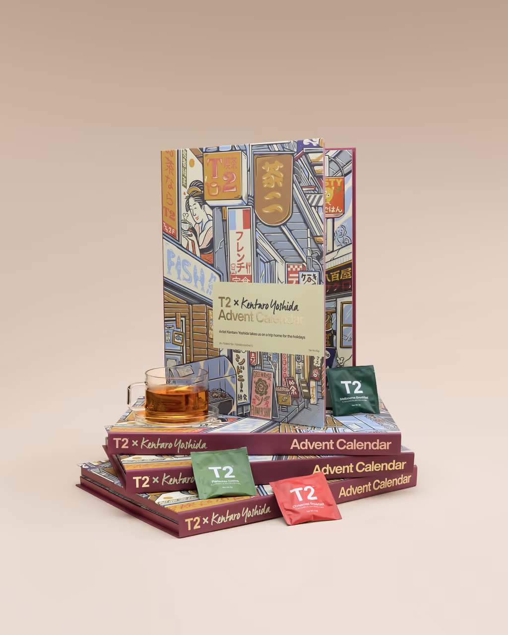 The calendar standing on two stacked boxes with a glass of tea and tea sachets around it