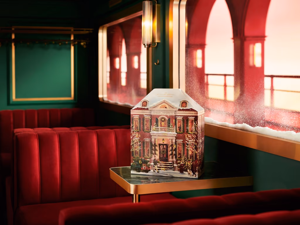 The pop-up house standing on a marble table in a green-panelled railway carriage