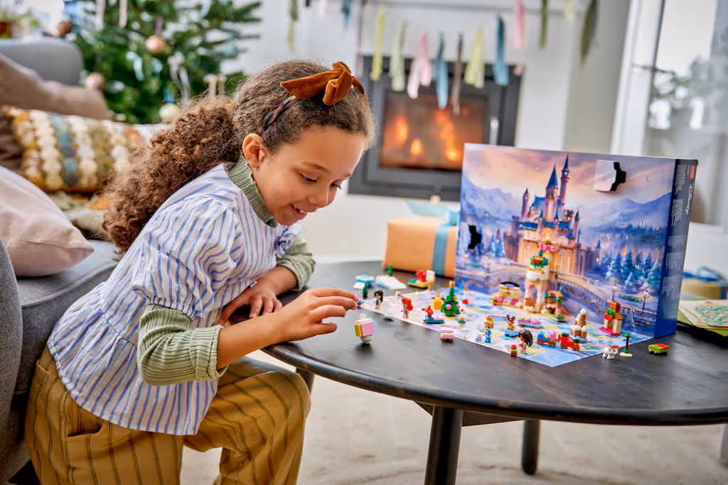 A child playing with the LEGO Disney Princess 2026 microdolls on the opened game board