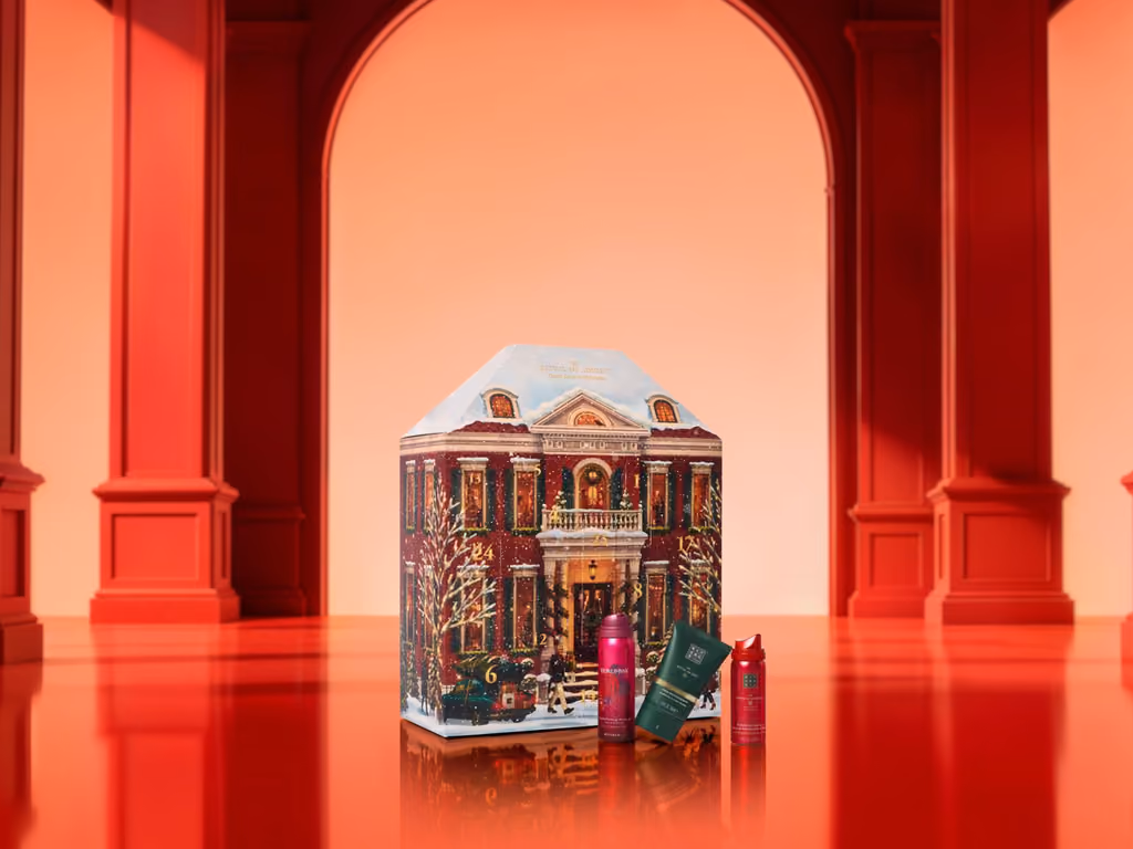 The Rituals townhouse calendar on a red stage with three products standing in front of it