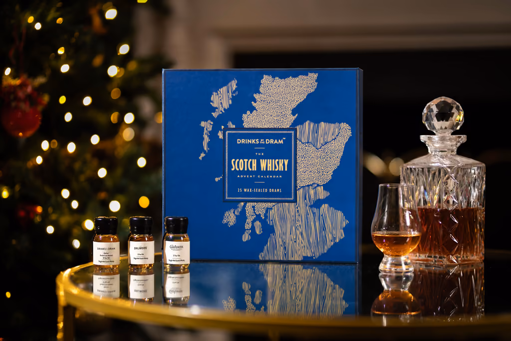The blue Scotch box on a gold table with three drams and a decanter