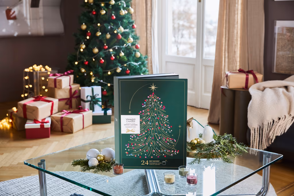 The calendar on a glass table beside a Christmas tree with wrapped presents