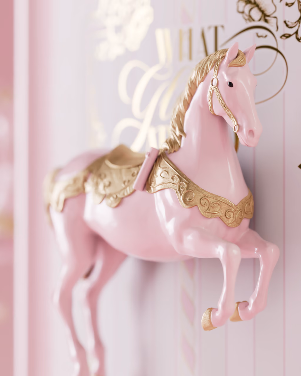 Close-up of one of the 3D pink-and-gold carousel horses on the side of the box
