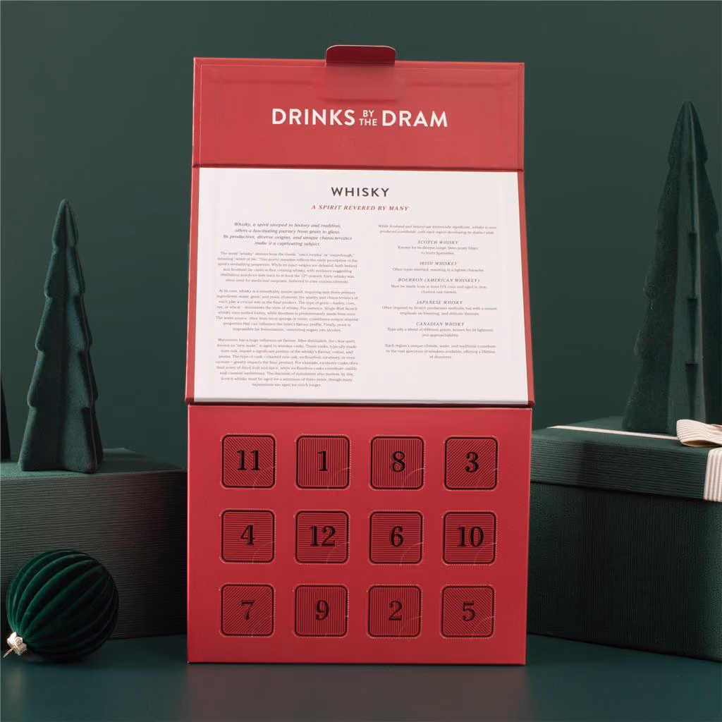 The box with its lid raised over 12 numbered doors and a whisky guide