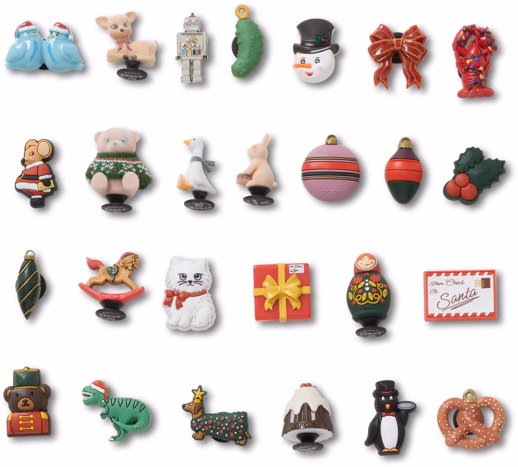 All 26 Jibbitz charms laid out in rows on white: baubles, animals, a robot, a pretzel and a letter to Santa