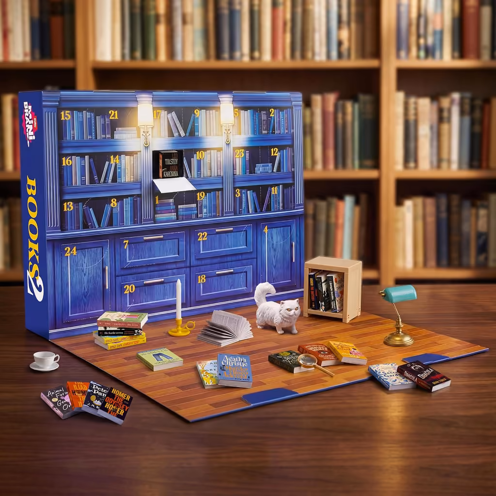 The open calendar on a table in a library, with the mini books and accessories set out on the mat