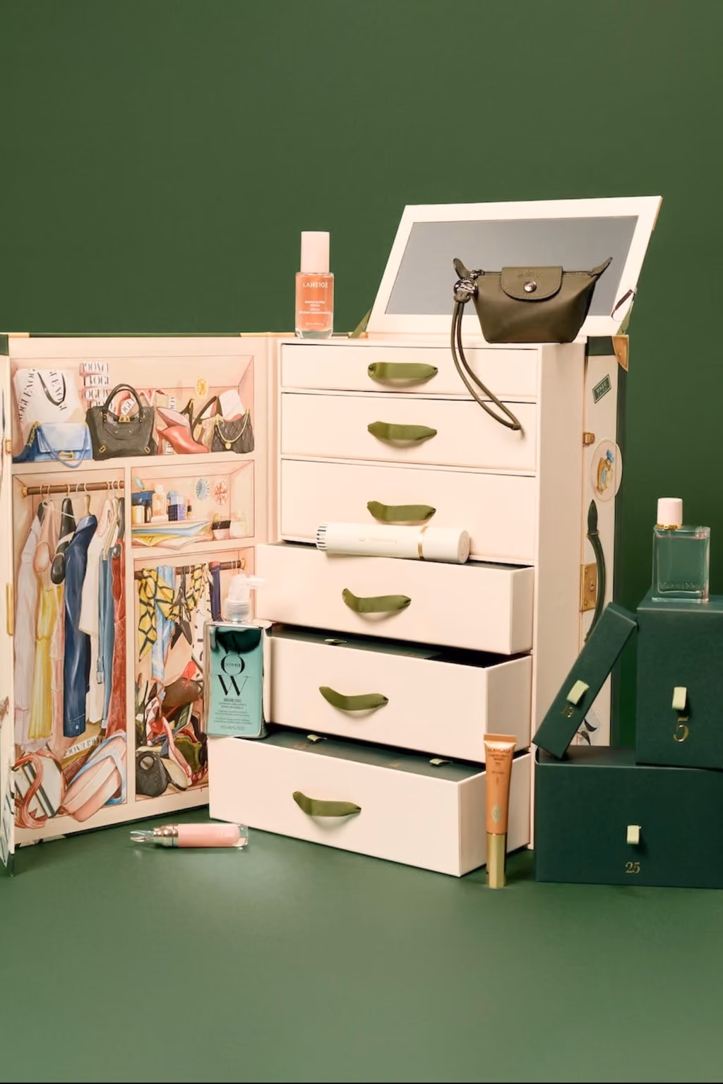 The Vogue Festive 2026 trunk open, drawers pulled out with the Longchamp purse and bottles on top
