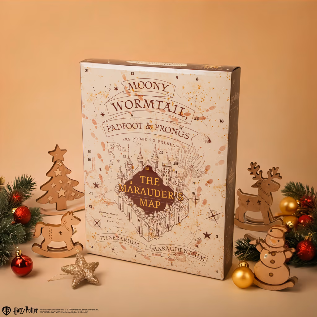 The Marauder's Map 2026 calendar propped on a table with wooden Christmas ornaments around it