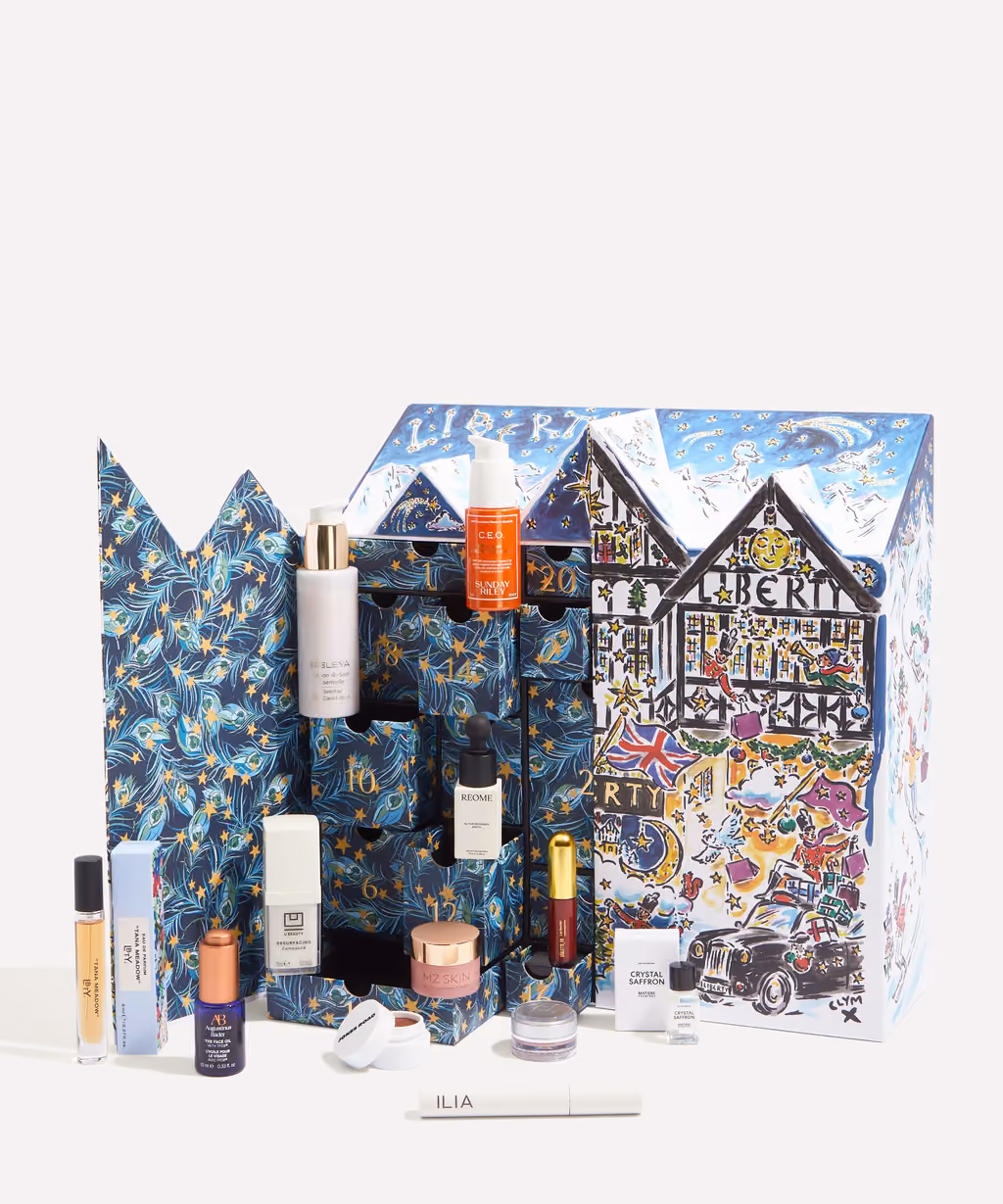 The Liberty Beauty 2026 calendar open, peacock-feather drawers pulled out with bottles standing on them