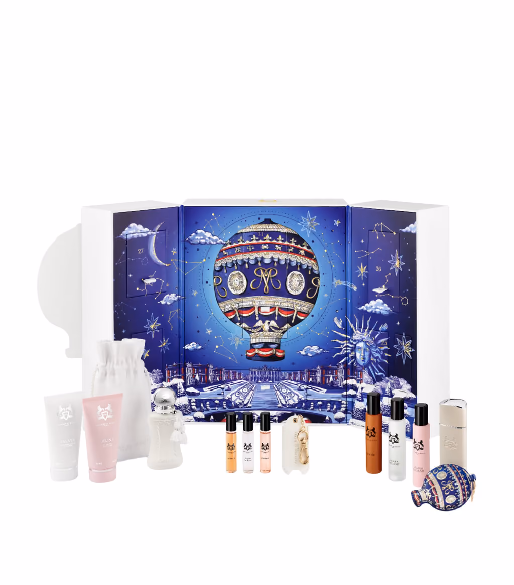 The open cabinet with the perfume bottles, tubes, pouch and keychain in front