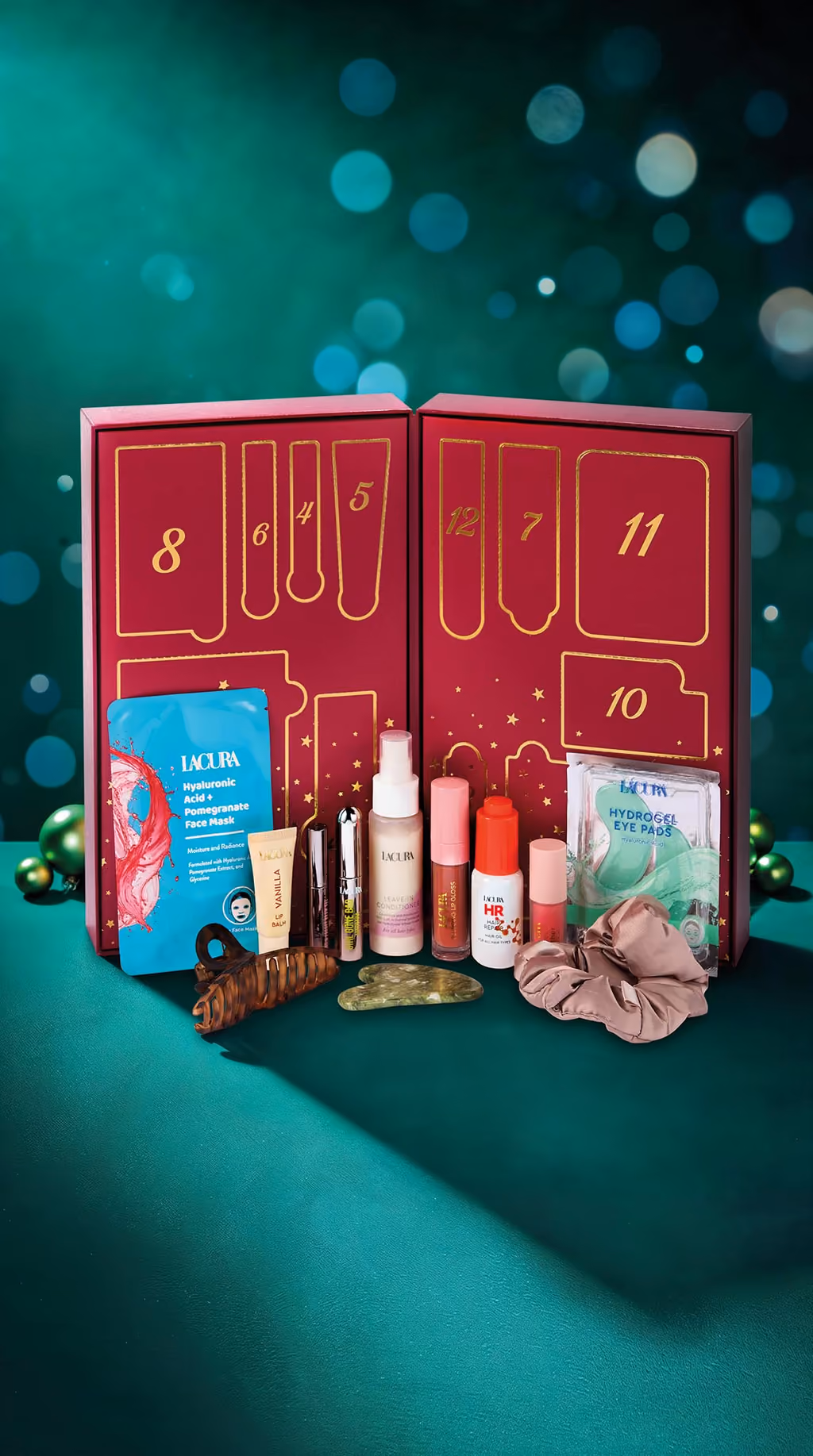 The open Lacura box with its thirteen products in front: sheet mask, lip balm, mascara, leave-in conditioner, lip gloss, hair oil, blush, eye pads, claw clip, gua sha and scrunchie