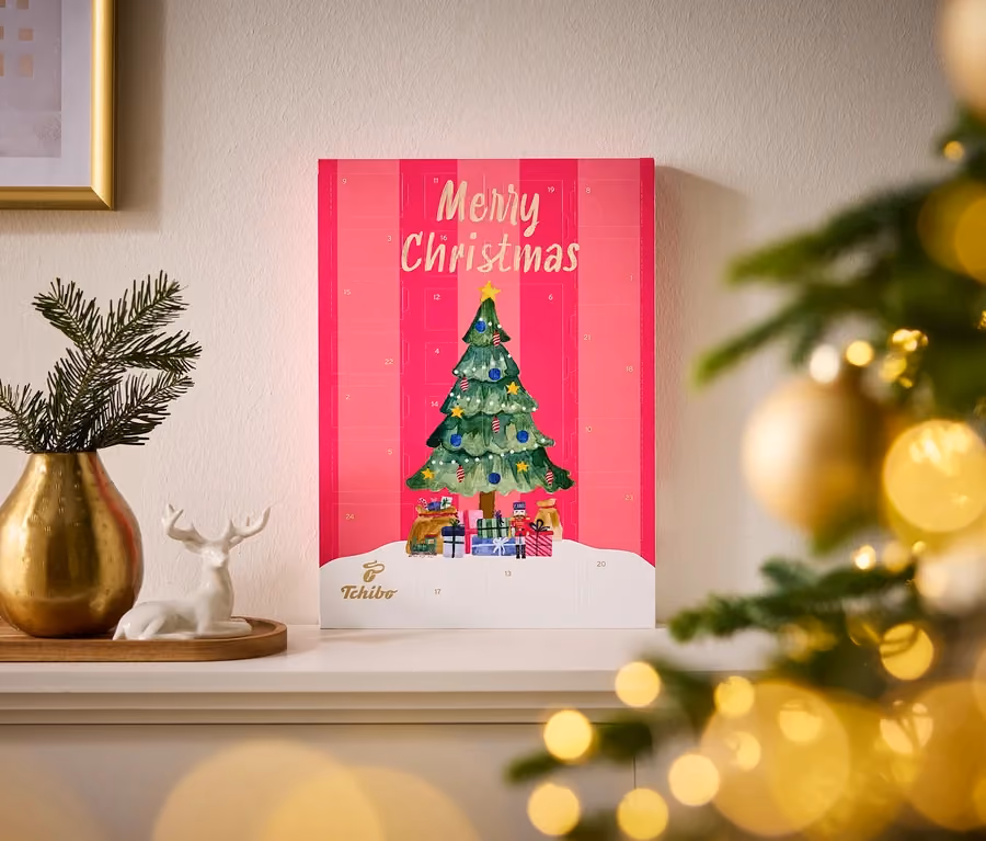 The pink Tchibo box on a mantelpiece beside a brass vase and a ceramic reindeer