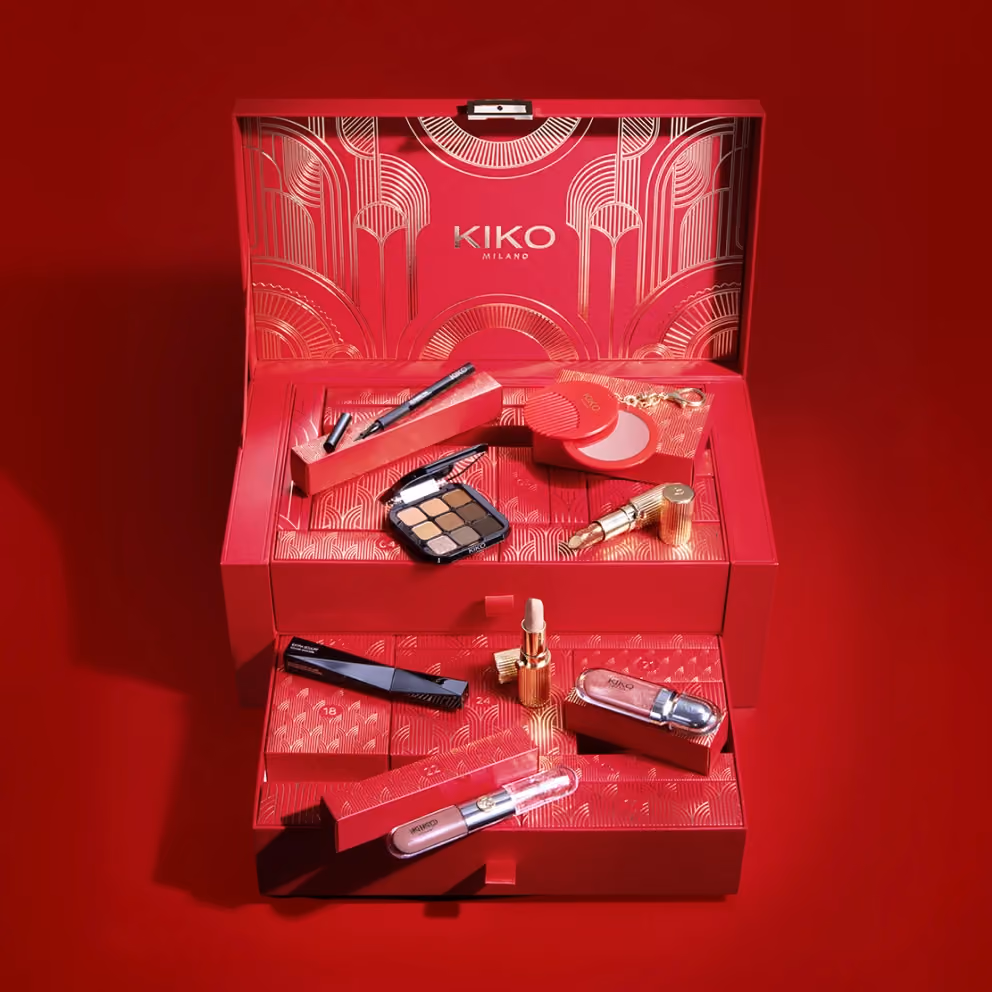 The red KIKO chest open, with the eyeshadow palette, mascara, lipsticks and gloss arranged on its drawers