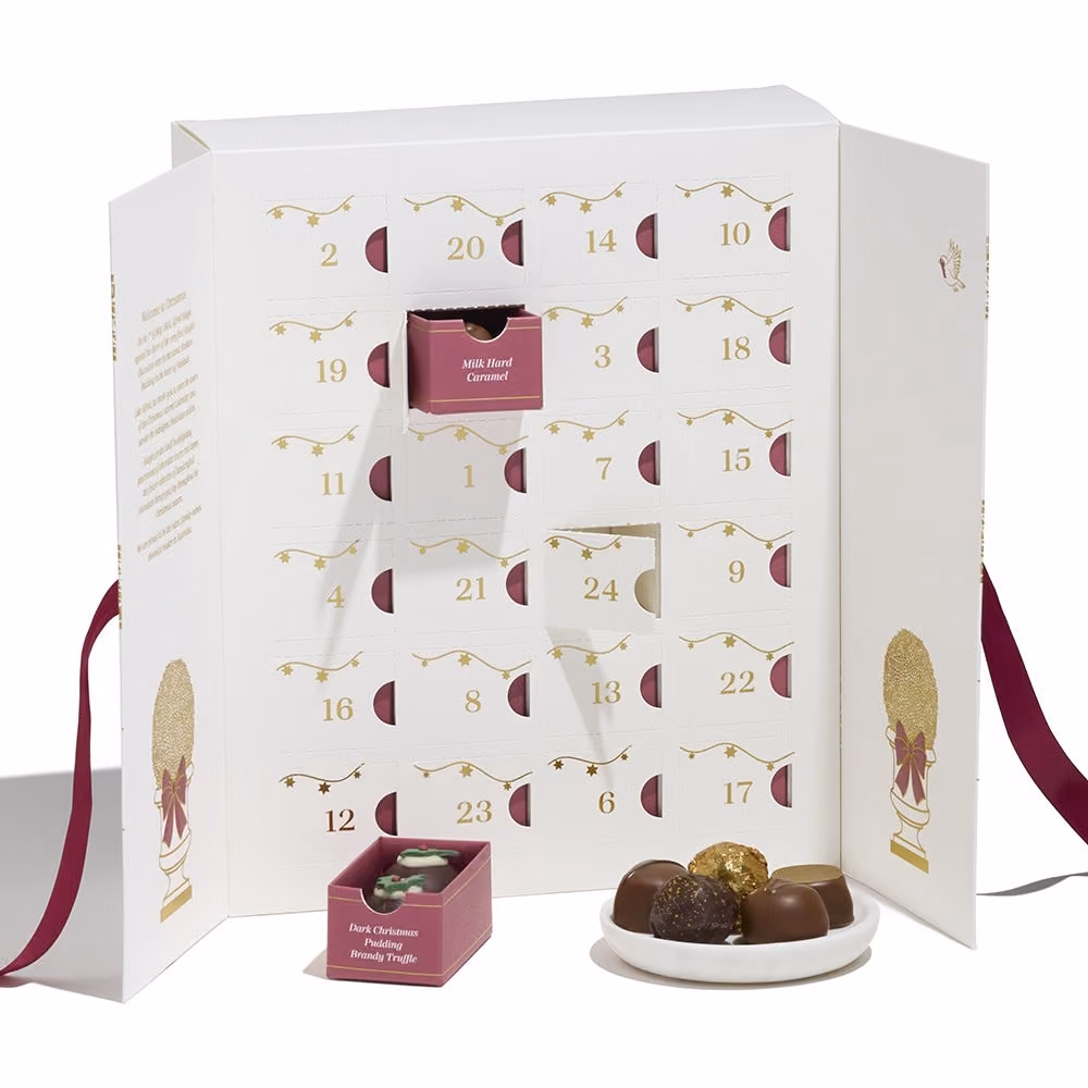 The open cabinet with two drawers pulled out and chocolates on a dish