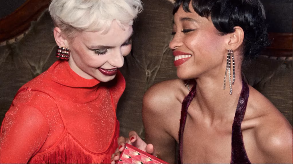 Two women in red and burgundy opening a Twist 'N Twinkle door together