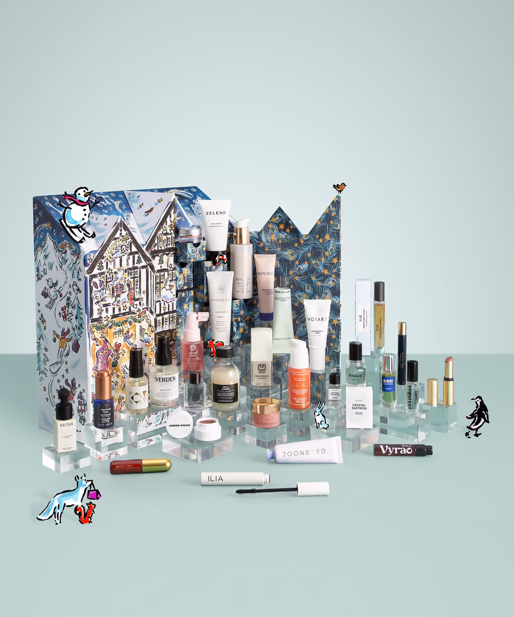 The house-shaped Liberty Beauty 2026 box with its 29 products on acrylic risers in front, on a sage backdrop