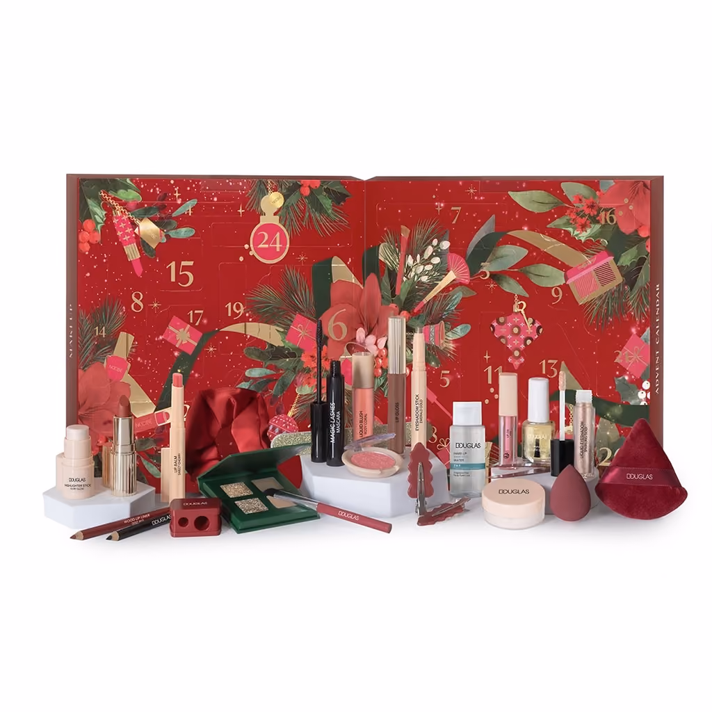 The red box open with lipsticks, palettes, sponges and bottles arranged in front