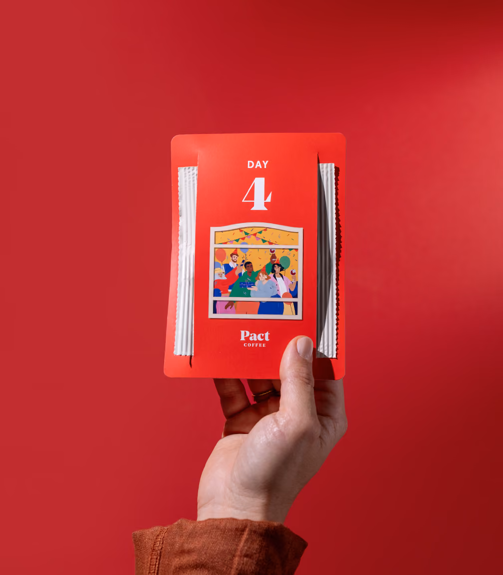 A hand holding the day 4 pouch against a red background