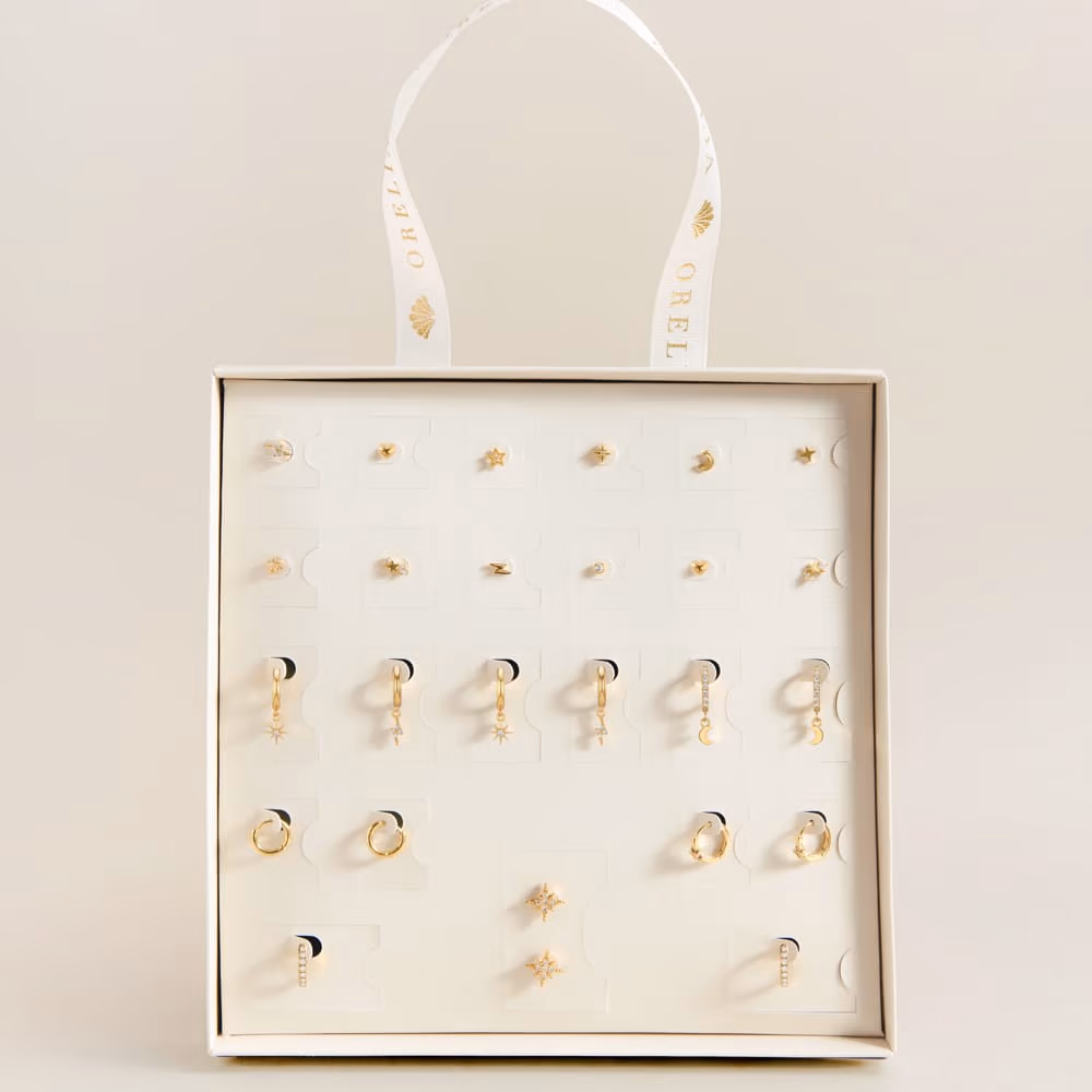 The box open with the gold earrings set out on its card in rows