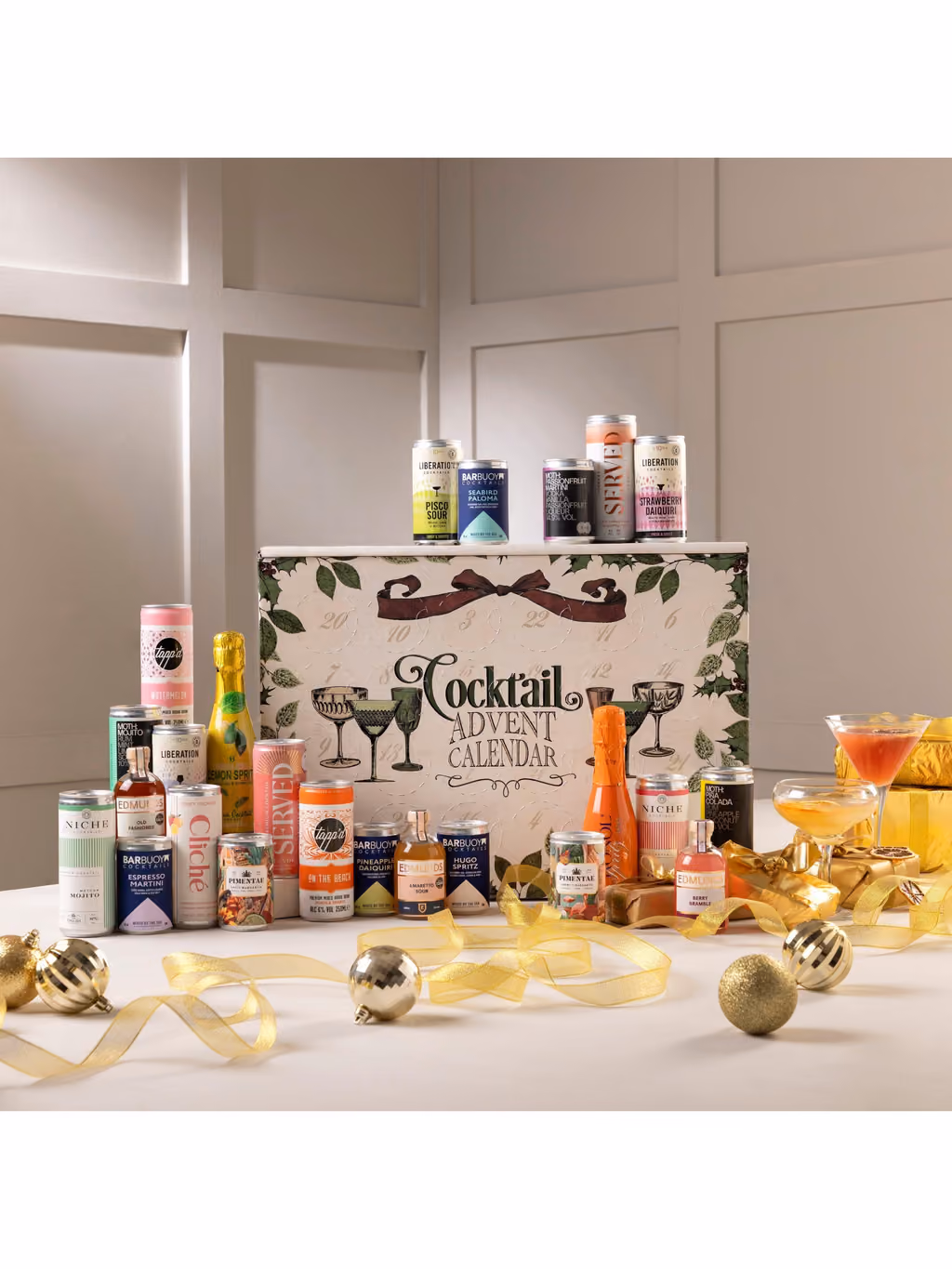 The box on a table with drinks stacked on top and gold ribbon