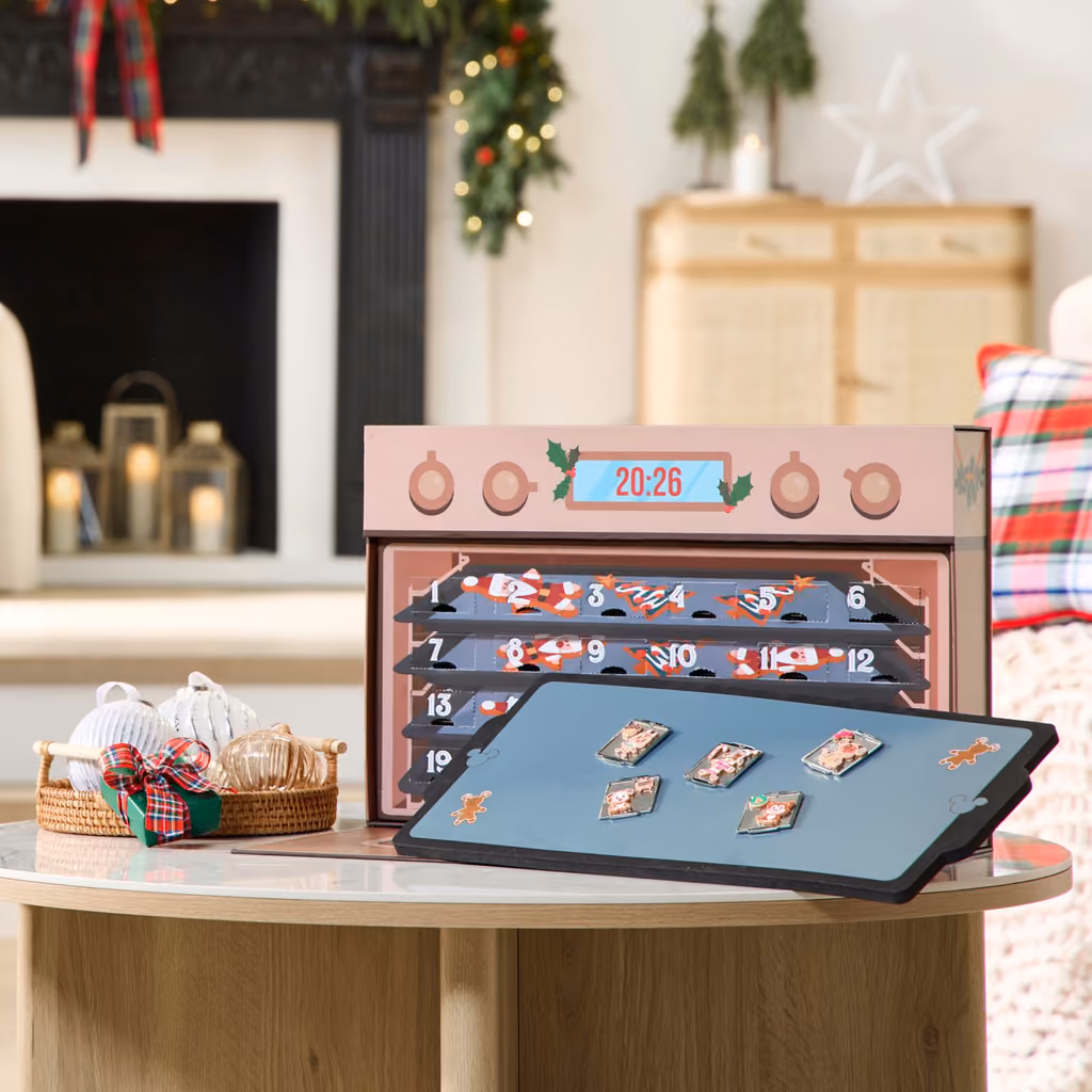 The oven open with numbered trays and a few cookie pins on the board