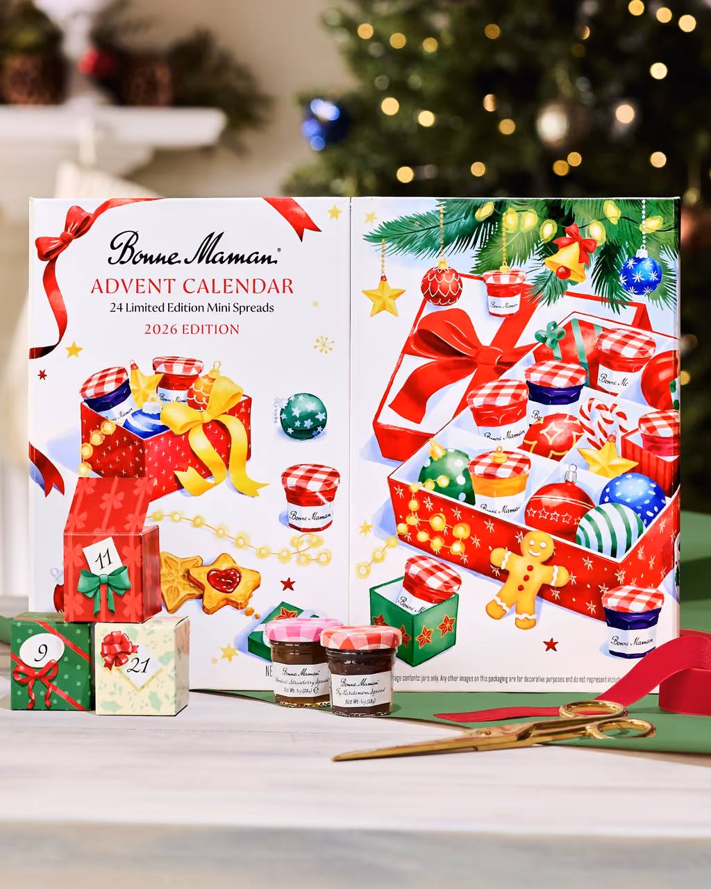 The Bonne Maman 2026 calendar on a table in front of a Christmas tree, two mini jars beside it