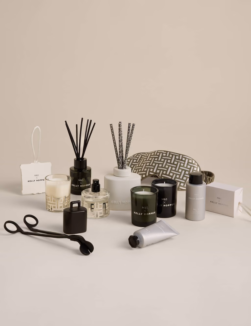 The twelve pieces laid out: votives, reed diffusers, body wash, hand lotion, pomander, snuffer and silk mask