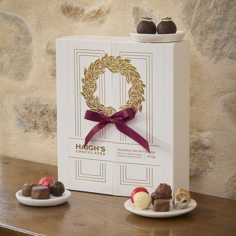 The closed box on a wooden table with chocolates on two plates